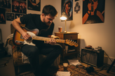 guitar player playing a solo in his room